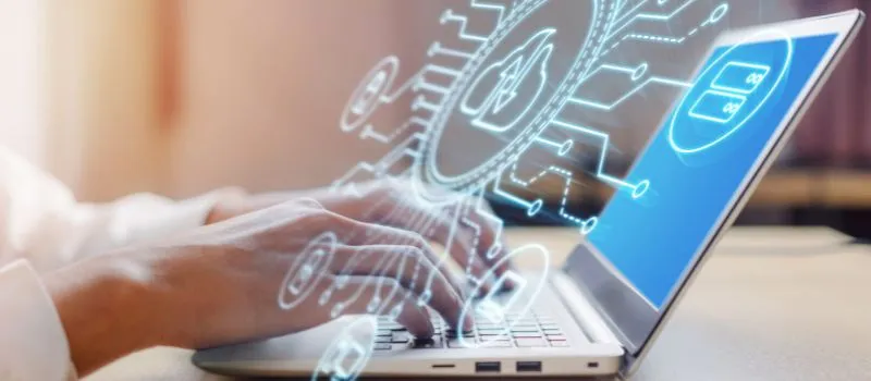 Person typing on a laptop with a glowing circuit and gear graphic showing data-governance icons