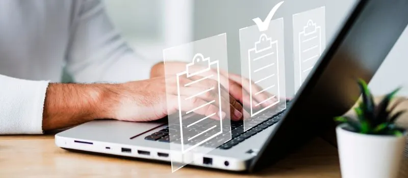 Person typing on a laptop with three overlaid clipboard icons, one marked complete with a check mark